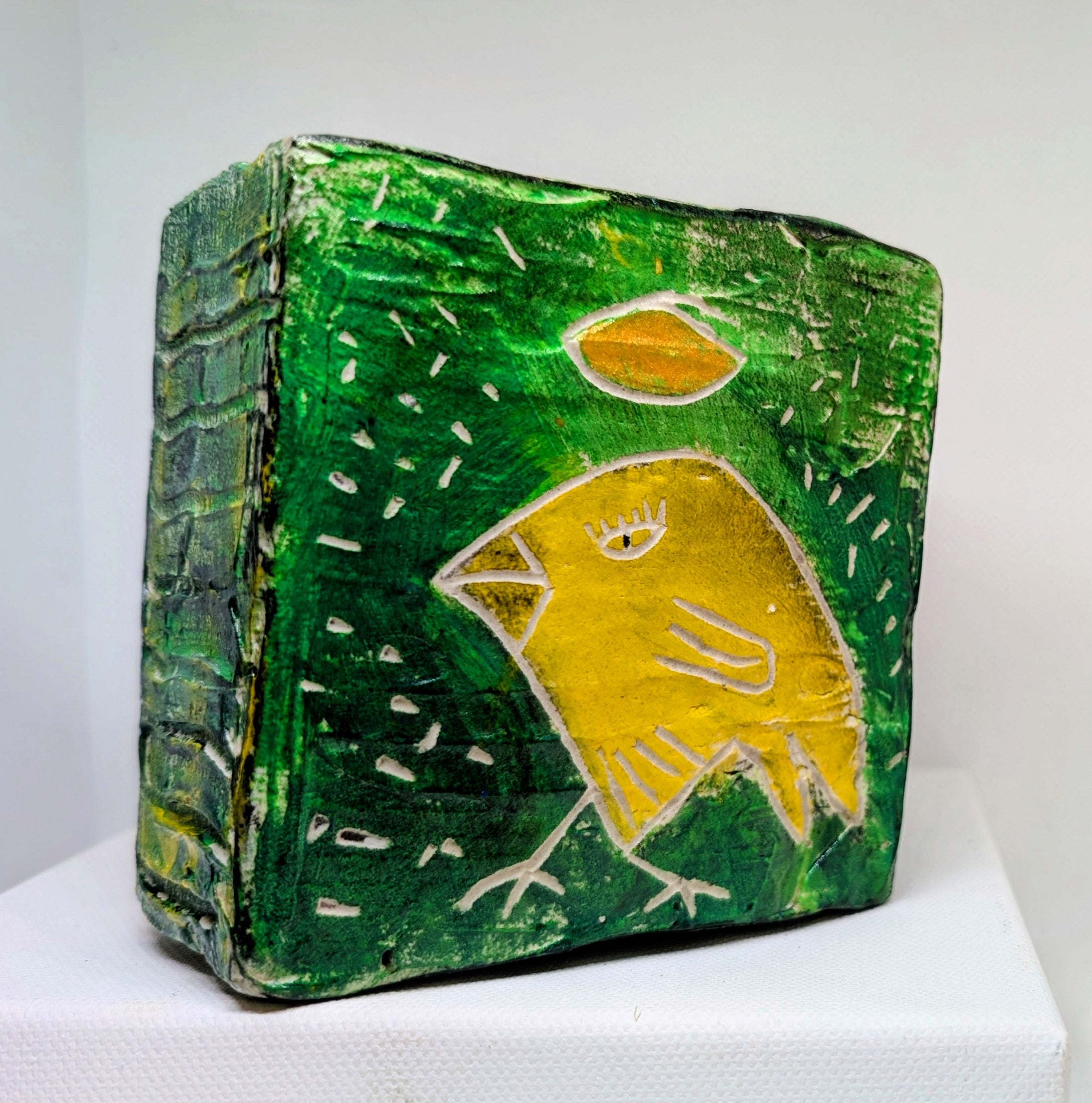 Yellow bird icon:  Textured bird painted block on upcycled material